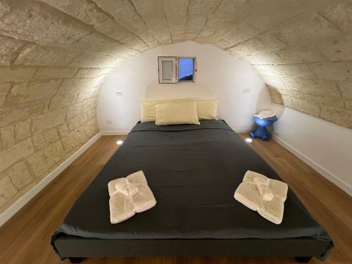 a bedroom with a bed with two white towels at Casetta Aurora in Bari