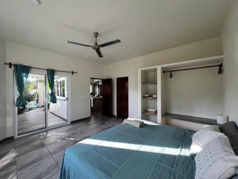 ein Schlafzimmer mit einem Bett mit Deckenventilator in der Unterkunft Casa de las Aves in Puerto Escondido
