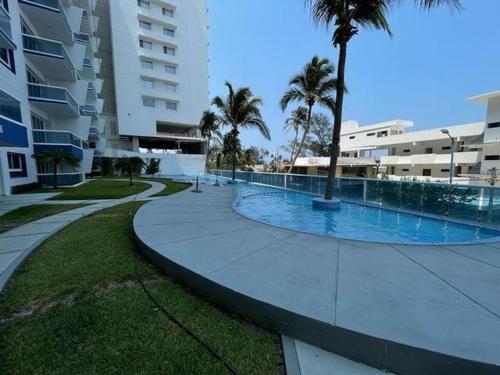 a large swimming pool next to a large building at Elefante blanco in Boca del Río