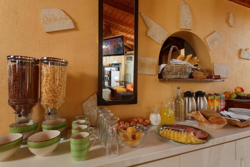 un comptoir avec des bols et des assiettes de nourriture dans l'établissement Danelis Studios & Apartments, à Mália