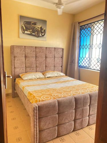 a bedroom with a large bed with a car on the wall at SuNRISE LUXURY HOMES in Mtwapa