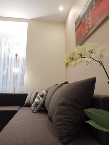 a living room with a couch with a pillow and a plant at Apartament Violet in Krosno