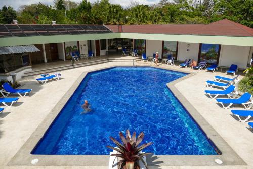 a pool with chairs and a person in the water at Hotel Bougainvillea San José in Santo Domingo