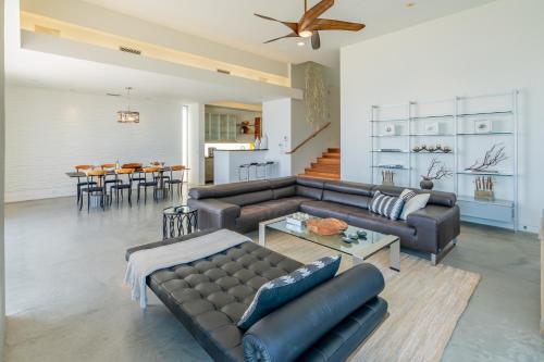 a living room with a leather couch and a table at Seascape by Paradise Retreats in Carpinteria