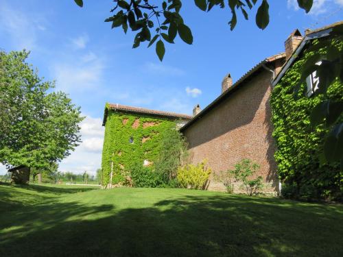 a brick building with green ivy on the side of it at Gîtes de La Carrétarié in Parisot