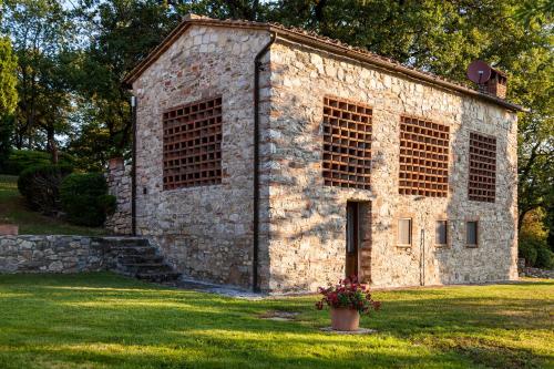 an old stone building in a field of grass at Querceto Di Castellina in Castellina in Chianti