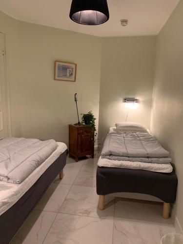 two twin beds in a room with a lamp at Svea Hostel in Stockholm