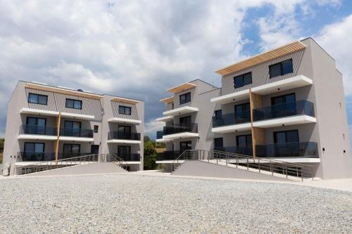 an apartment building with balconies on a beach at Calma Luxury Suites in Paralia Dionysiou
