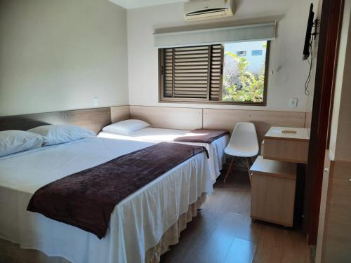 a bedroom with a large bed and a window at Hotel Poty in Maracaju