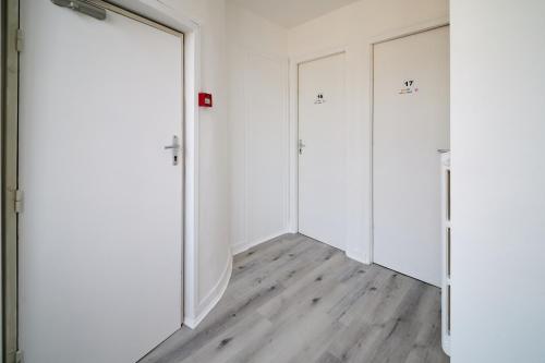 an empty room with two doors and a wooden floor at La Caravelle in Riom