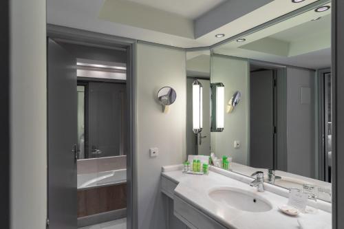 a bathroom with a sink and a large mirror at Rodos Park in Rhodes Town