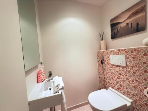 a bathroom with a toilet and a sink at Bright 2BR flat w free parking&outdoor space in Mamer