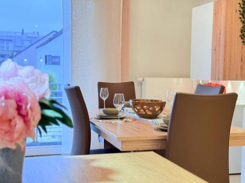 a dining room table with chairs and a table with a vase of flowers at Bright 2BR flat w free parking&outdoor space in Mamer