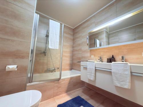 a bathroom with a shower and a toilet and a sink at Bright 2BR flat w free parking&outdoor space in Mamer