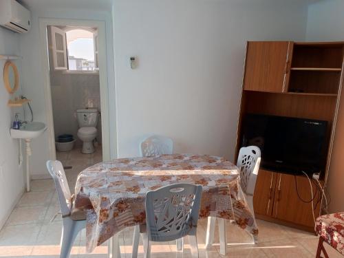 a dining room with a table and chairs and a television at Studio AMINE in Mahdia
