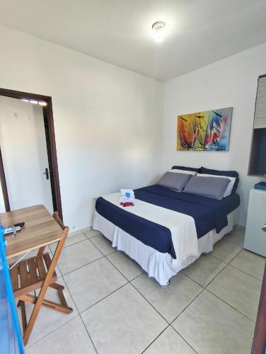 a bedroom with a large bed and a table at Ponta Negra Suites & Apart in Natal
