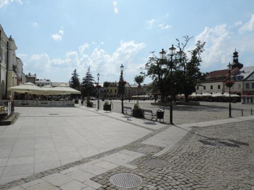 a city square with benches and tables and buildings at Apartament Green in Krosno