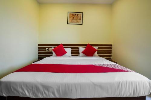 a bedroom with a large bed with red pillows at Hotel O Pariwar Inn in Hyderabad
