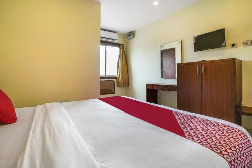 a bedroom with a bed with a red and white blanket at Hotel O Pariwar Inn in Hyderabad