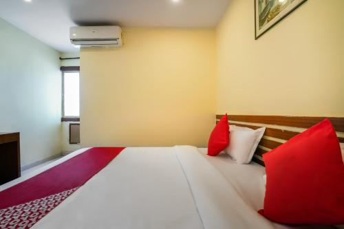a bedroom with a bed with red and white pillows at Hotel O Pariwar Inn in Hyderabad