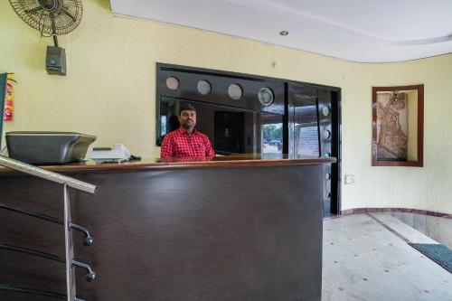a man standing behind a bar in a restaurant at Hotel O Pariwar Inn in Hyderabad