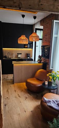 a living room with a couch and a kitchen at Apartament Przy Murach in Toruń