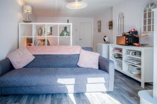 a living room with a blue couch and white shelves at Portway Nook - 1 Bedroom Studio - Bishopston in Bishopston