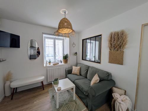 a living room with a couch and a table at La Maison Des Caps AU BLANCNEZ in Marquise
