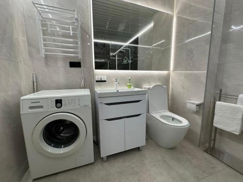 a bathroom with a washing machine and a toilet at ALVINA Complex Tsaghkadzor in Tsaghkadzor