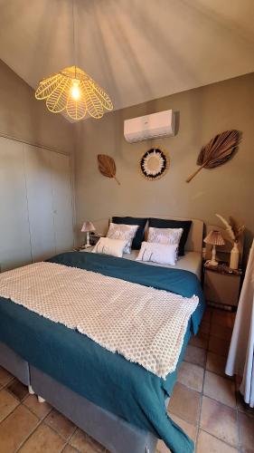 a bedroom with a large bed and a chandelier at Villa Sisyphe chambre d'hôtes "la Mariette" in Le Thoronet