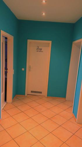 an empty room with a white door and blue walls at Cozy appartement in oberbarmen in Wuppertal