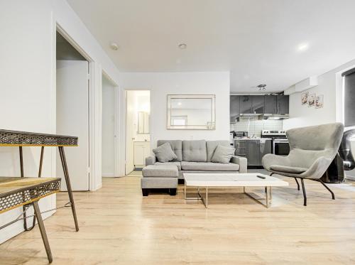 a living room with a couch and two chairs and a table at Superbe 2 chambres à Griffintown in Montréal