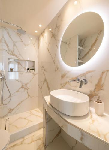 a white bathroom with a sink and a mirror at Azure Escape in Karterados