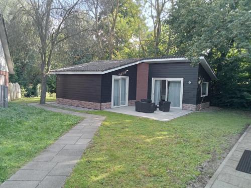 a small black house with a grass yard at Domstad Resort Utrecht Vakantiewoningen in Utrecht
