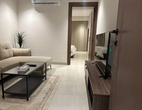 a living room with a couch and a tv at أجنحة رافينا هاوس - Ravina Suites in Riyadh