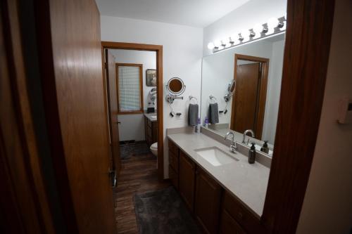 a bathroom with a sink and a mirror at Whispering Woods Estate - Relax, Recharge, Connect - 12 wooded acres, 3 Bedrooms, 3 Baths, sleeps 10 in Rockton