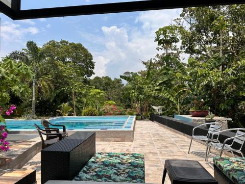 an outdoor patio with a swimming pool and chairs at Finca Casa Mercedes rivera in Rivera
