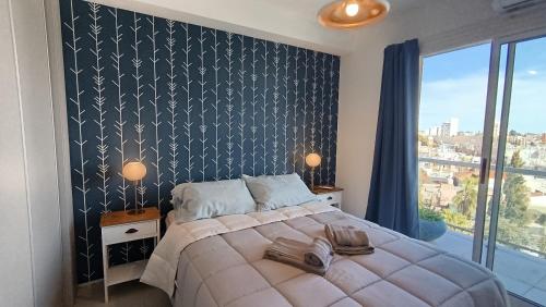 a bedroom with a large bed with a black and white wall at Apart Alameda in Paraná