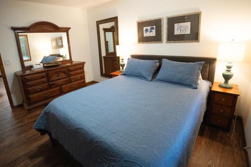 a bedroom with a bed and a dresser and a mirror at Whispering Woods Estate - Relax, Recharge, Connect - 12 wooded acres, 3 Bedrooms, 3 Baths, sleeps 10 in Rockton