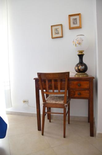 a wooden desk with a chair and a vase on it at La Bocciarda in Ceglie Messapica