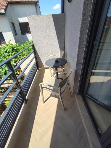 a small table and chair on a balcony at Vila Karlovčanka smeštaj u centru Sremskih Karlovaca in Sremski Karlovci