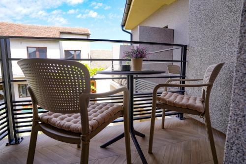a balcony with two chairs and a table on a balcony at Vila Karlovčanka smeštaj u centru Sremskih Karlovaca in Sremski Karlovci