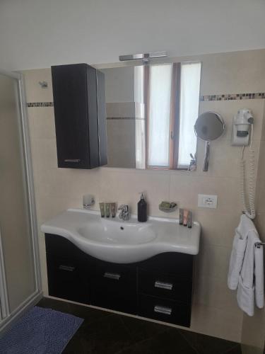 a bathroom with a white sink and a mirror at ROOMS CA' TUNIN- ideale per il Trenino Rosso- a pochi minuti a piedi dalla stazione in Tirano