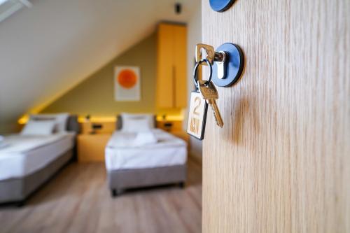 a door with a key in a room with beds at Vila Karlovčanka smeštaj u centru Sremskih Karlovaca in Sremski Karlovci