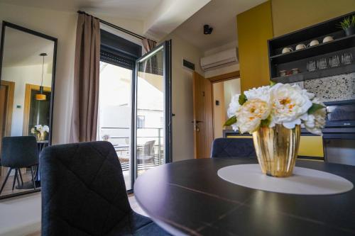 a vase of flowers on a table in a room at Vila Karlovčanka smeštaj u centru Sremskih Karlovaca in Sremski Karlovci
