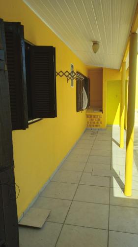 a room with a yellow wall and a tile floor at CASA COM 3 QUARTOS, SENDO 1 QUARTO Suite in Pinhal