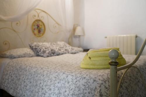a bedroom with a bed with a yellow blanket on it at Agriturismo La Colombella in Bagni San Filippo
