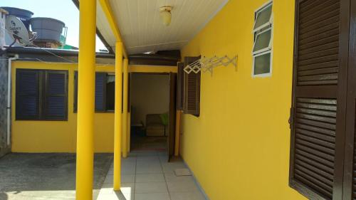 a yellow house with a yellow wall at CASA COM 3 QUARTOS, SENDO 1 QUARTO Suite in Pinhal