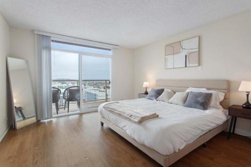 een witte slaapkamer met een groot bed en een balkon bij Marina Edge Bright 1BR 1BA Condo by the Beach in Los Angeles