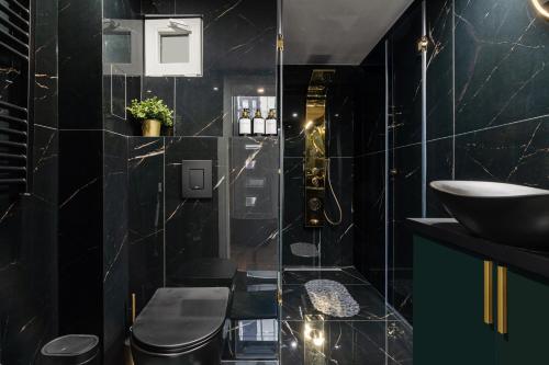 a black bathroom with a sink and a shower at Csarnok Apartment in Budapest